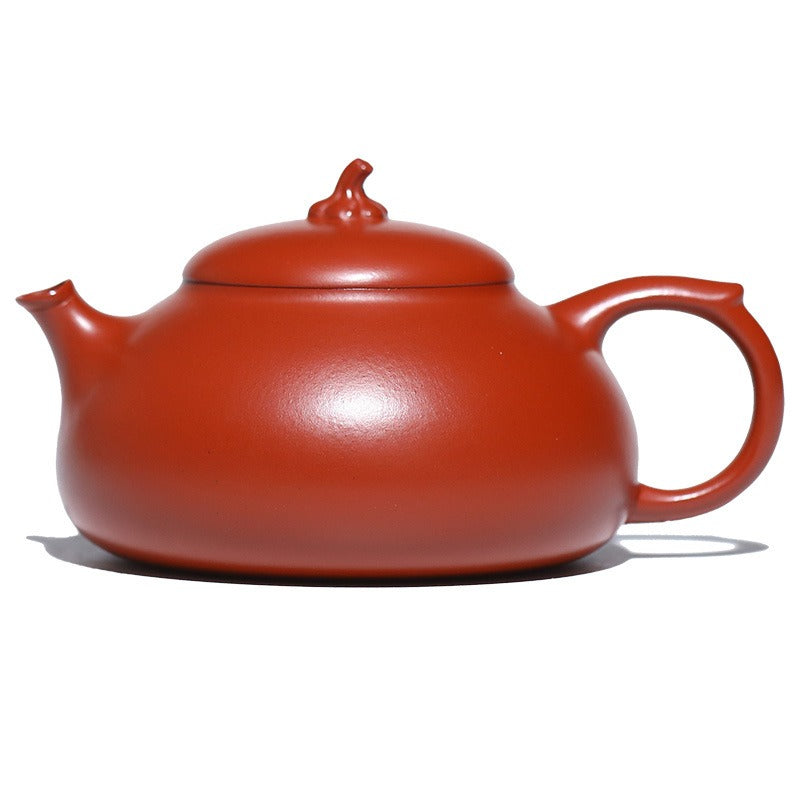 Red ceramic teapot on a white background