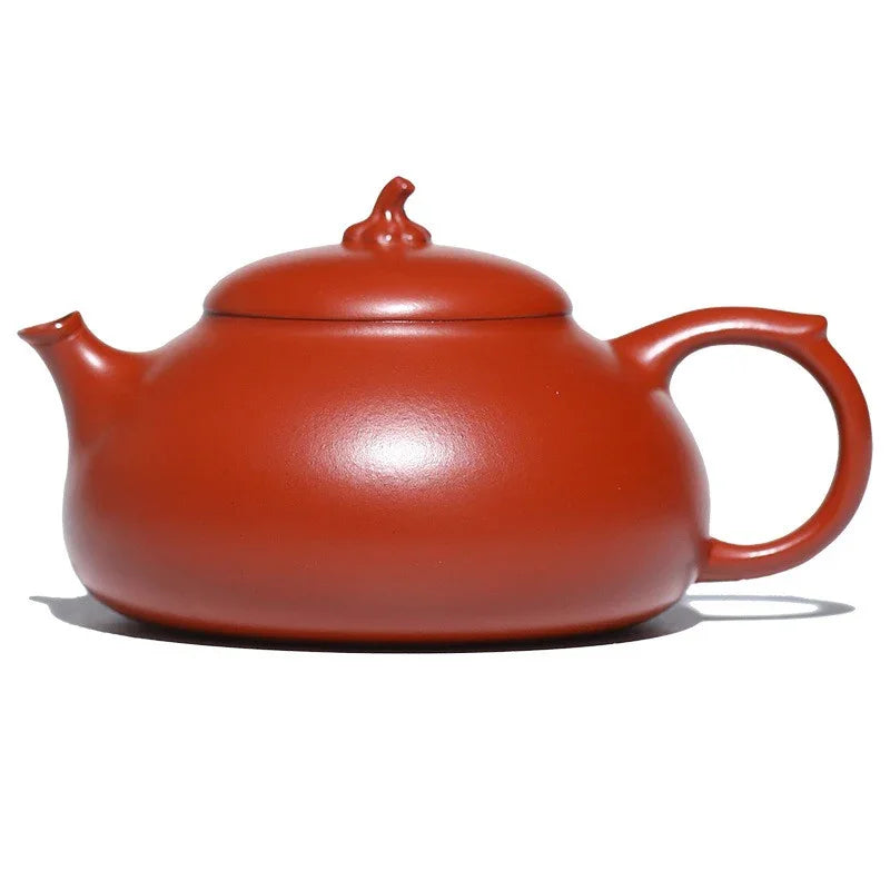 Red ceramic teapot on a white background