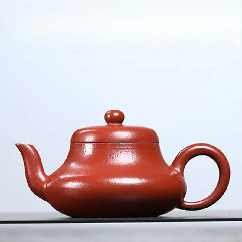Red ceramic teapot on a light gray background
