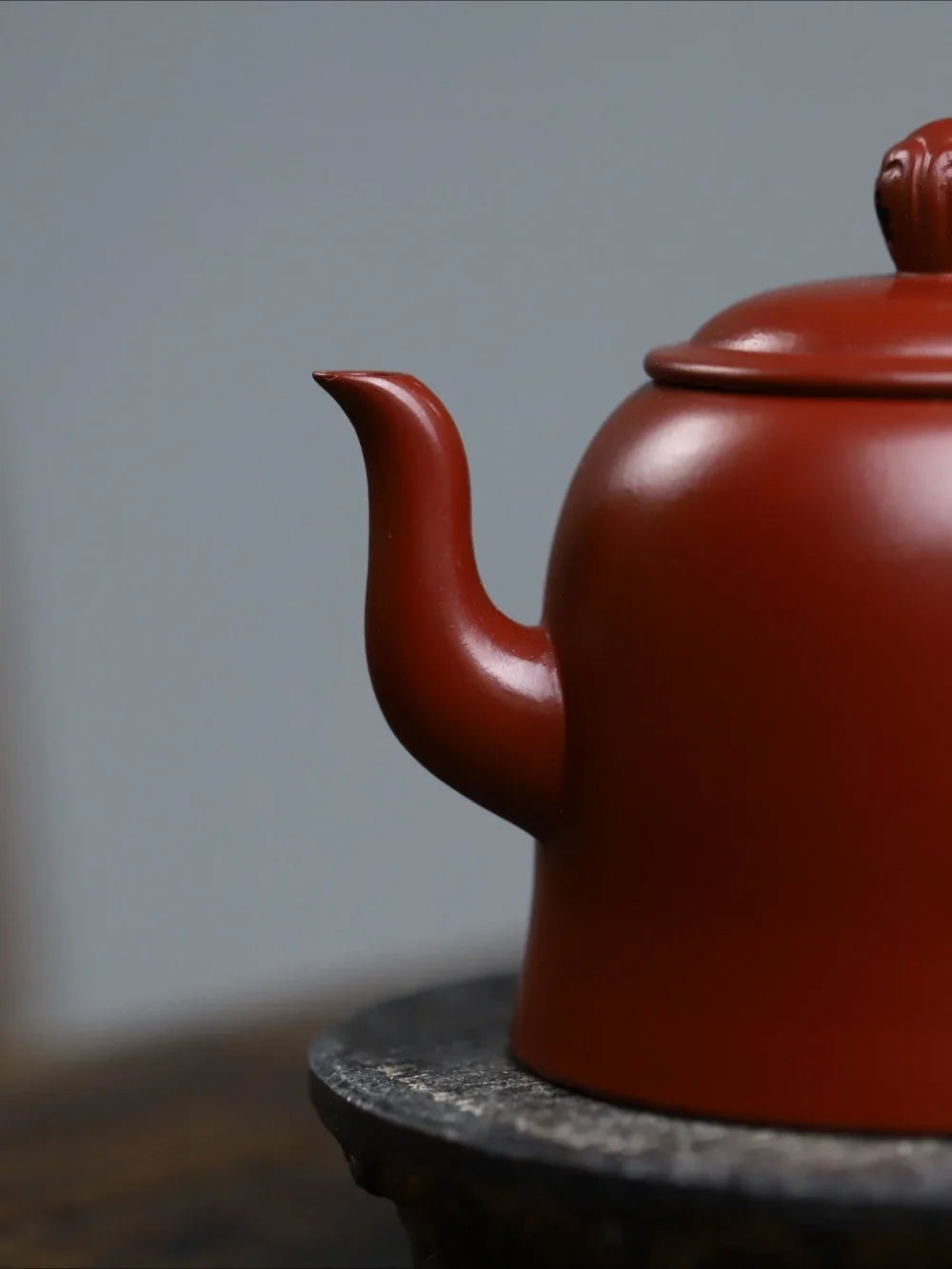 Red teapot on a dark surface with a blurred background


