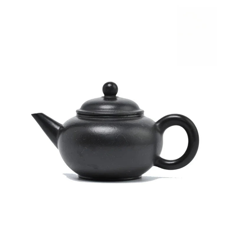 A classic black ceramic teapot with a rounded body, loop handle, and spout, shown on a plain white background.

