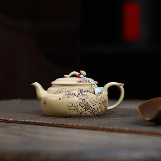 Beige ceramic teapot with intricate designs on a dark surface

